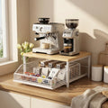 Coffee-making setup with espresso machine, grinder, and coffee beans on a wooden counter.